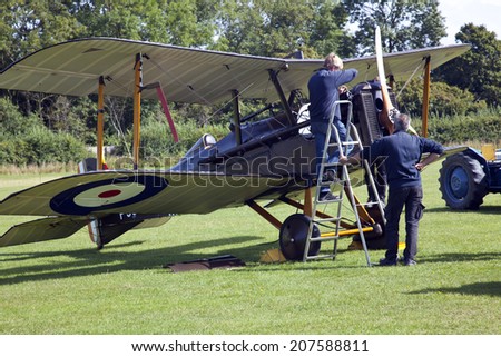 England UK circa 2014 Unamed engineers prepare a vintage BiPlane at a vintage air pageant
