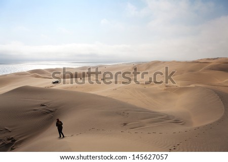 a woman walking on the dunes of the desert