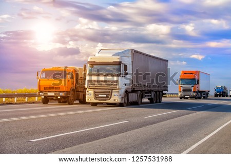 trucks goes on highway in evening on sunset