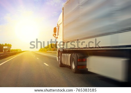 big truck goes on the highway to sunrise