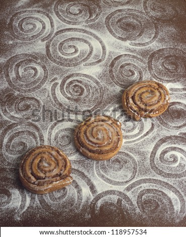 advertising atelier photography with spiral sweet cakes and abstract spirals drawn into flour powder