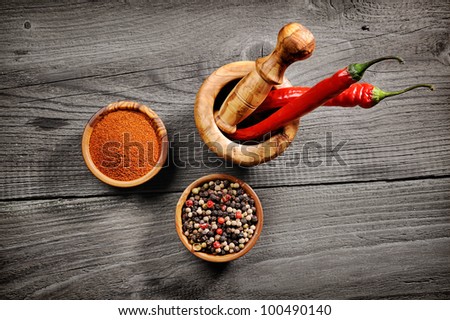 red hot chili peppers in old mortar on old wooden table