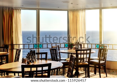 interior of a dinner lounge on a cruise ship - with a round table and windows with panorama seaview