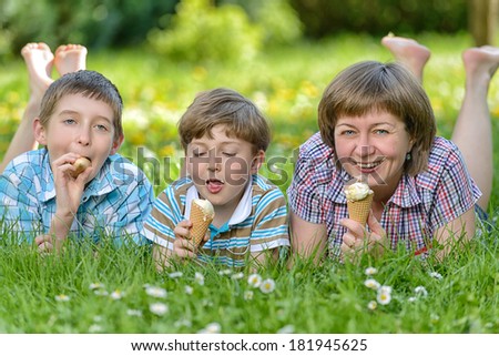 Happy family eat ice cream on a grass outdoors in spring park