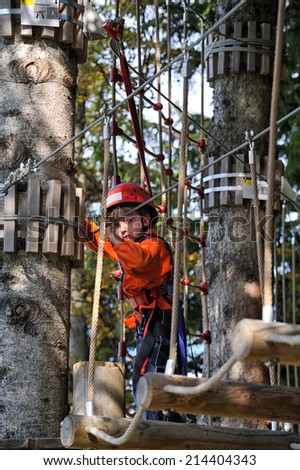 adventure climbing high wire park - people on course in mountain helmet and safety equipment