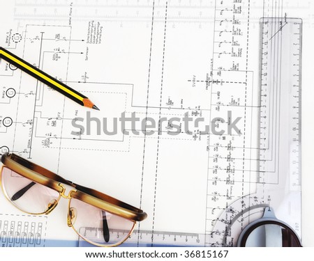 construction plan with pencil, glasses and ruler on it