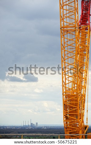 Crane on a construction site with industrial landscape background