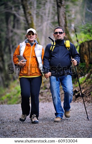 two people walking on a path through the forest - trekking