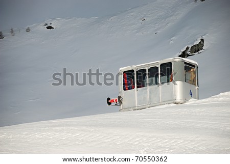 Out of order - nonworking old ski lift cabin standing on the ground in a snowy landscape