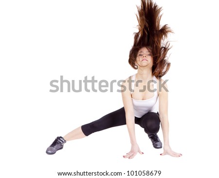 A young woman is stretching her body. She trains fitness. She lifts her head. The body in motion. You can see them through dispelled hair, it high above his head.