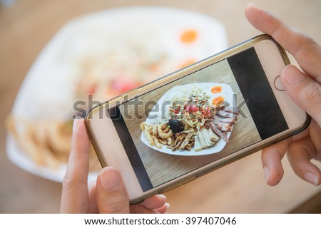 Woman hands taking food photo by mobile phone. Food photography. Share food photography. Thai food. Popular food. Delicious food.