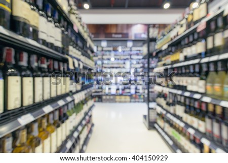 defocused/ Blurred image of bottles of wine on the shelves in supermarket. Background blur. Wine background. Shelf background. Wine background.Bottle background. Storage background.