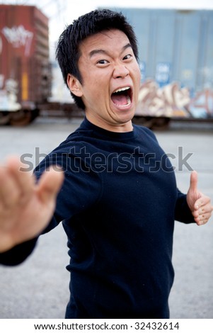 An angry asian man performing karate moves toward the camera