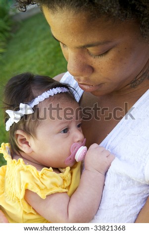 An African American Mother holder her child with a pacifier