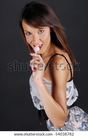 stock photo Girl licking lollipop over black background
