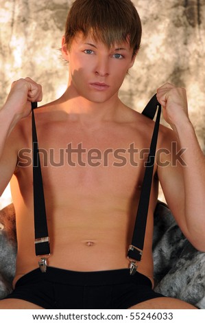 Boy with nude chest and suspenders over painted background