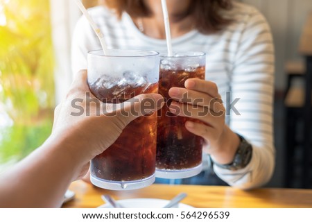 Men and Woman hand giving glass of cola.Glass of cola ,Soft drinks with ice, sweetheart or buddy
