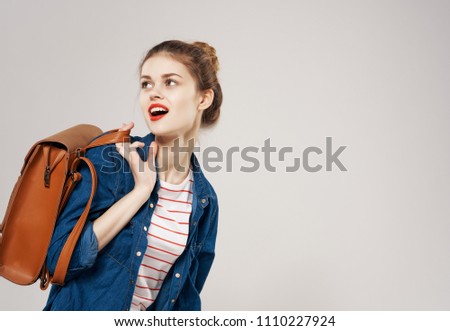 a woman in a blue shirt and with a brown backpack looked back