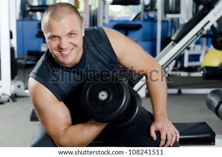 The man with dumbbells in sports club