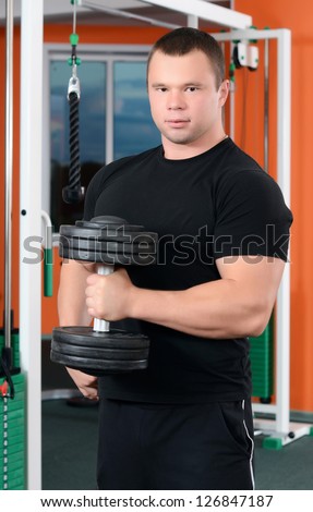 The man with dumbbells in sports club