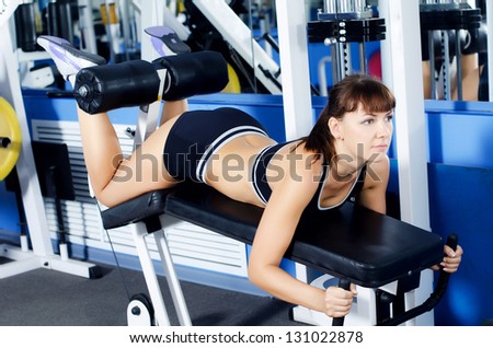 Woman on training apparatus in sports club