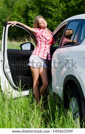 Beautiful girl stands near to white car