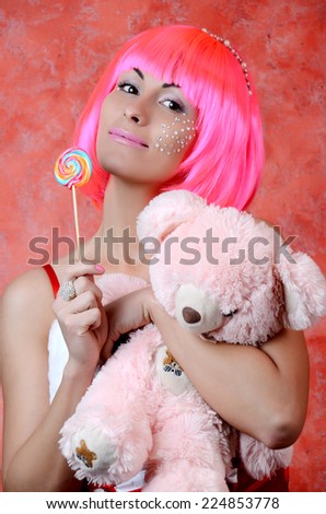 woman laughing with candy and beautiful make-up  whith taddy bear
