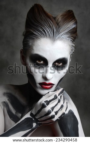 Young woman with dead mask skull face art. Halloween face