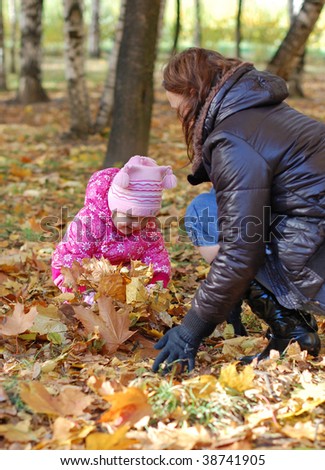 Mum with a daughter walk in autumn park