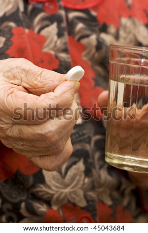 The old woman drinks a tablet