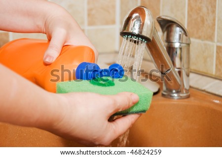 The woman pours a washing-up liquid