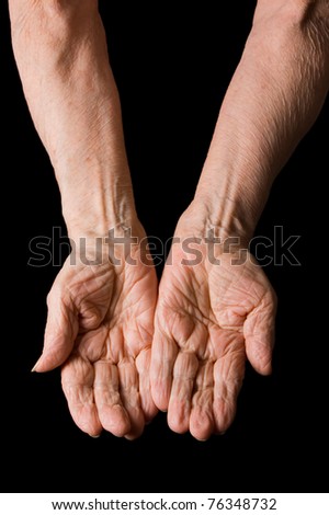 Hands of old elderly woman on black background