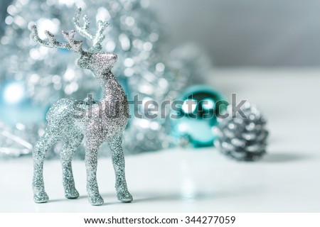 Silver Deer with silver star and Christmas tree and blue ball on background. Silver and blue Christmas ornaments.Xmas theme for your text and design.