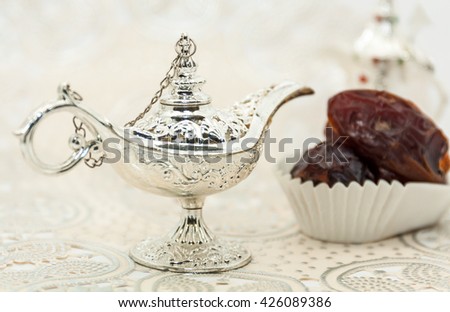 Ramadan Eid background. Silver Alaadin\'s lamp and date fruits and dallah