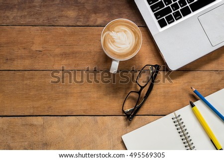 Office desk table with blank paper page, pencil, pen, glasses, laptop and cup of coffee.Top view with copy space.Office supplies and gadgets concept.