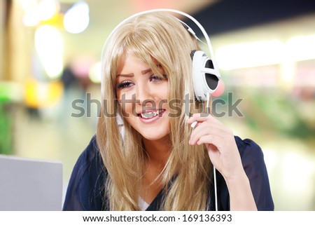Internet telephony, happy girl on computer headset in public venue