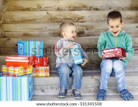 children enjoy gifts. Two cute brothers are happy with gifts