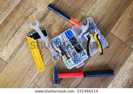 set of tools and a box of nails. work tools and dowels in a beautiful wooden background