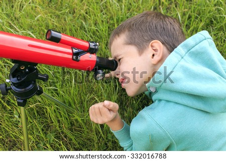 look in the telescope. Boy studying cosmic bodies looking through a telescope