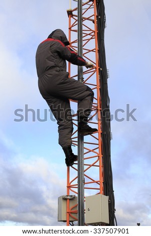 violation of safety at high-altitude works. worker climbs the stairs to the telecommunication towers without a safety harness and safety equipment