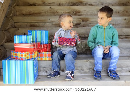 envious child. elder brother is jealous of a pile of gifts that are gifted to younger brother