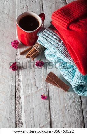 red scarf and hat with cinnamon on white wood. winter mood on Valentine\'s Day