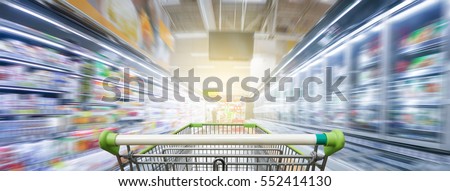 Panorama. Supermarket aisle with empty green shopping cart