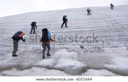 Six people trekking on a glacier.
