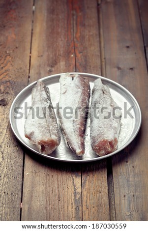 Cooking from frozen: frozen gutted fish without head on a tray