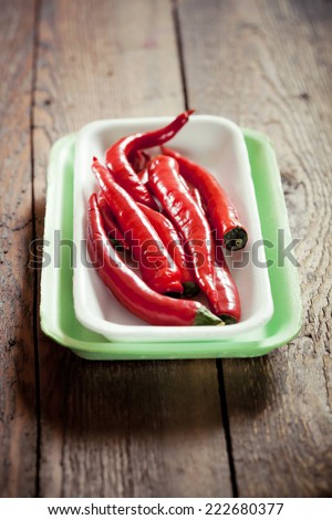Chili peppers on plastic supermarket trays, on old wooden table