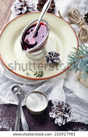 Cranberry sauce or berry jam for Christmas dinner, set with Christmas decorations
