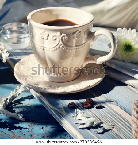 Cup of espresso set on a wooden table, natural light setting. Toned photo