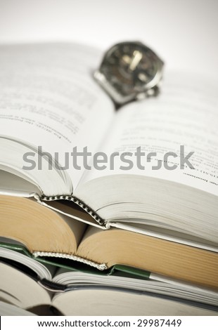Close-up of books bindings and a watch, shallow DOF