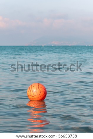 Orange ball for water games floating in the sea